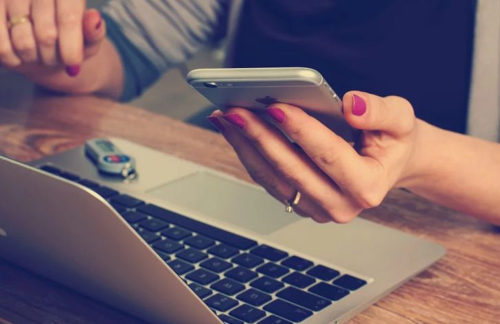 Смартфон в руке, ноутбук