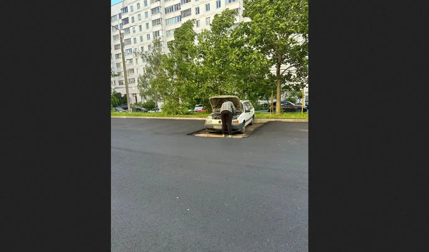 В Минске асфальт уложили вокруг припаркованного автомобиля человек и автомобиль