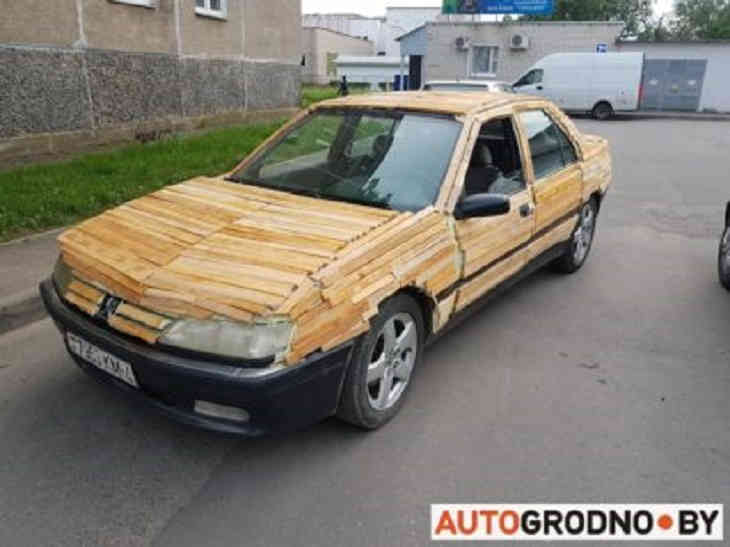 Окружающие недоумевают. В Лиде молодой парень обклеил дровами свою машину