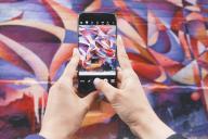 смартфон Samsung в руках, граффити