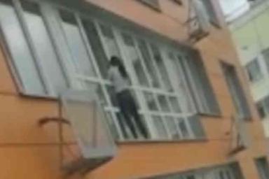 Отчаянная домохозяйка помыла окна своей квартиры на 15-м этаже, стоя снаружи